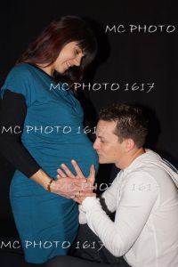 photo-grossesse-couple-homme-sui-embrasse-le-ventre-femme-robe-bleue-charente