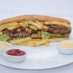 sandwich américain avec steack hachés et frites oignons avec sauce publicité pour entreprise de cognac charente