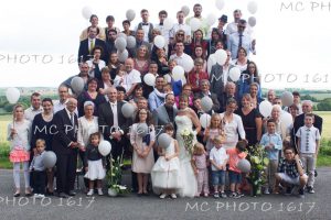 photo-groupe-mariage-avec-remorque-gradins-invites-tiennent-ballons-gris-et-blanc